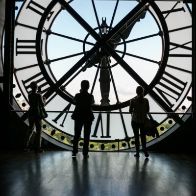 3 people standing inside big clock